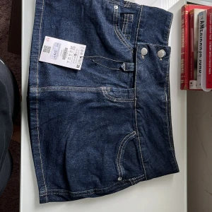 Mörkblå jeanskjol med short  - Säljer en mörkblå jeanskjol med shorts  från Bershka är helt ny jag har aldrig använt den  Priset kan diskuteras!!
