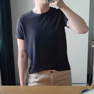 Lee T-shirt - Svart t-shirt från Lee med rund halsringning och korta ärmar, en clean och enkel look med diskret logga i nederkant. Lite lite "genomskinlig" i ränderna, så lite av det man har under syns vilket gör att man kan styla den både till mer vardags-snygg och utekväll ;) 