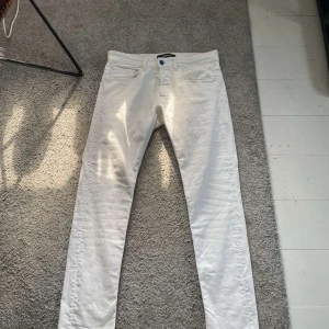 Vita Replay Willbi jeans slim fit - Snygga vita jeans från Replay, modell Willbi med slim fit. Klassisk femficksdesign, blå Replay-patch bak och smal passform. Perfekta för dig som vill ha ett fräscht och stilrent par jeans med modern känsla. Använda en gång, som nya!
