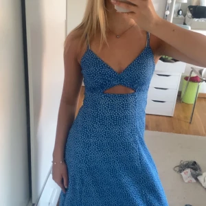 Blå blommig klänning med cut-out - Säljer denna superfina långklänningen! Storlek xs men passar även s💕Endast använd en gång