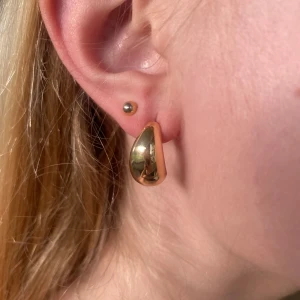 Chunky droppformade örhängen i guld - Säljer ett par chunky örhängen i droppform med spegelblank yta i guldton. Nästan aldrig använt.