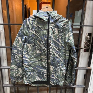 Camouflage vindjacka från Tretorn - Säljer en snygg windbreaker från Tretorn i storlek M. Jackan har gröna, beige och blå toner och har praktiska fickor på sidorna. Det är en unik jacka från Tretorns provkollektion. Finns inte att köpa. Kom gärna med frågor