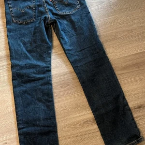 Levis 501 jeans - Klassiska Levis 501 jeans i en mörkblå nyans. De har en rak passform och är tillverkade i slitstarkt denim. Perfekta för en tidlös stil.