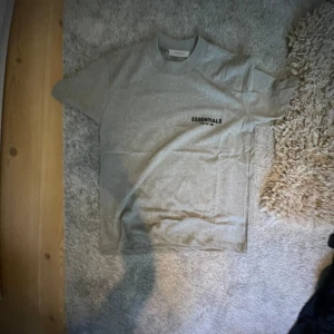 Grå t-shirt från Essentials Fear of God - Säljer en grå t-shirt från Essentials Fear of God. Stolek xs men passar s. Helt ny oanvänd