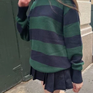 Randig stickad tröja från Brandy Melville - Säljer en stickad tröja från Brandy Melville med breda mörkblå och gröna ränder. Tröjan har lång ärm, rund halsringning och ribbade muddar. Har en lös sömm/tråd vid ena armen som syns i andra bilden. 