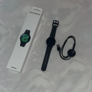 Samsung Galaxy Watch4 med grått armband - Säljer en Samsung Galaxy Watch4 med grått silikonarmband. Smartklockan har rund urtavla, GPS, Wi-Fi och Bluetooth. Passar perfekt för dig som vill ha koll på hälsa, träning och notiser direkt på handleden.