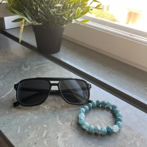 Solglasögon och armband - Riktigt sköna svarta solglasögon perfekta till sommaren, på köpet får du även ett fräscht armband. Allt detta till ett riktigt bra pris
