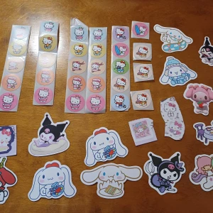 Hello Kitty och Sanrio Stickersamling - En färgglad stickersamling med Hello Kitty och andra Sanrio-karaktärer som Cinnamoroll, Kuromi och My Melody. Perfekt för att dekorera anteckningsböcker, laptops eller mobilskal. Söt och lekfull design som passar unga fans av kawaii-kultur. Cirka 46 stycken 