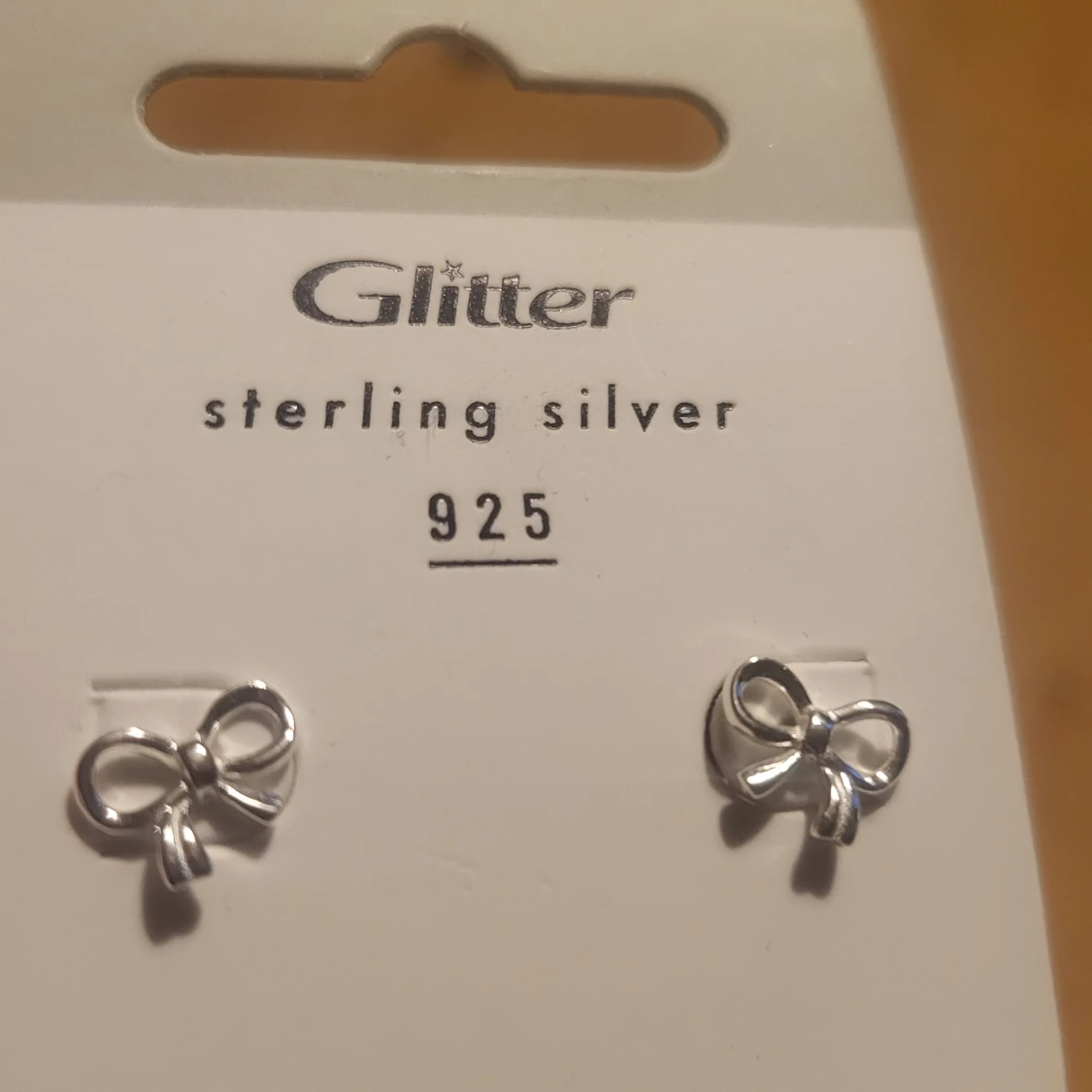 Coquette Silvriga rosettörhängen från Glitter