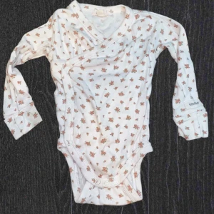 Barn body från Newbie - Ljusrosa långärmad bebis body ifrån Newbie. Inga fläckar vad jag kunnat se. Storlek 68, fint skick.  (10)