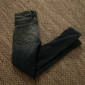 Mörkblå Replay jeans - Säljer ett par mörkblå jeans från Replay (anbass model) med en snygg fade. Byxorna är i toppskick och är inte använd fler än 5 gånger! Kontakta vid vidare information!