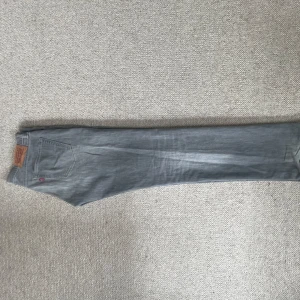 Grå jeans Levis 511 herr - Säljer ett par grå Levis 511 jeans i herrstorlek W32 L34. Klassisk femficksmodell med rak/slim passform och Levis-logga på bakfickan. Perfekta till dig som gillar stilrena och tidlösa jeans.