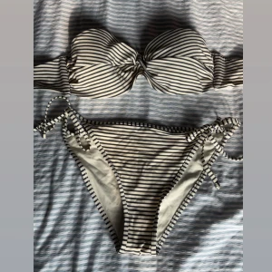 Randig bikini - Snygg bikini med svartvita ränder och knyt i sidorna på underdelen. Överdelen är bandeau-modell.