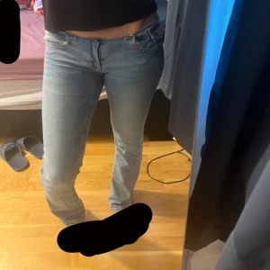 Ljusblå jeansbyxor med låg midja - Säljer ett par ljusblå jeansbyxor med låg midja och klassisk femficksdesign. Jeansen har en rak passform och stängs med dragkedja och knapp framtill. Perfekta för en avslappnad och stilren look.