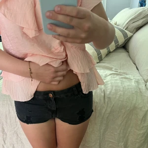 Svarta jeansshorts - Säljer ett par jättesnygga svarta, lågmidjade jeansshorts med lite slitningar nedtill. 💕