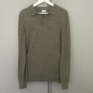 Grön stickad pikétröja från John Henric - Säljer en stilren grön stickad pikétröja från John Henric. Tröjan har klassisk krage, knappar vid halsen och långa ärmar. Skick: 9/10, inget fel på den men det finns tecken på användning. Nypris 1000kr