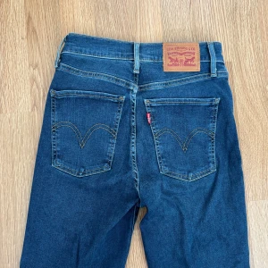 Levi's blå skinny jeans - Klassiska blå Levi's jeans med raka ben och femficksmodell. Byxorna har hög midja och tydliga sömmar på bakfickorna samt den ikoniska läderpatchen i midjan. Perfekta för en tidlös denimlook. Aningen stretchiga🩷 Storlek 25