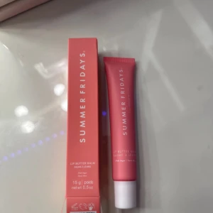 Lip Butter Balm från Summer Fridays - Lip Butter Balm från Summer Fridays i en rosa tub med vitt lock. Ger återfuktade och mjuka läppar med en lätt glans. Förpackningen innehåller 15 g och har en stilren design i rosa nyans. Färgen är Pink Sugar och helt helt oanvänd.