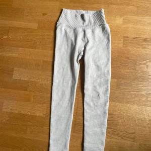 Beige ribbade träningstights från Aim'n - Säljer ett par beige ribbade träningstights från Aim'n med hög midja. De är stretchiga och har en tight passform, perfekta för träning eller en avslappnad stil. Klassisk Aim'n-logga på höften och mjukt material som sitter skönt hela dagen.