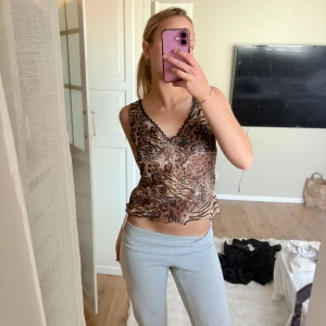 Leopardmönstrad linnetopp med spets - Säljer en croppad linnetopp med leopardmönster och svarta spetsdetaljer längs v-ringningen. Super fint! Lapp kvar, aldrig använd 