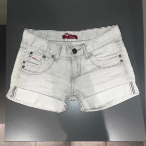 Lågmidjade grå jeansshorts - Supersnygga Lågmidjade jeansshorts från Squallity Jeans i stl 26💕  Midjemått: 36 cm  Grenhöjd: 17 cm