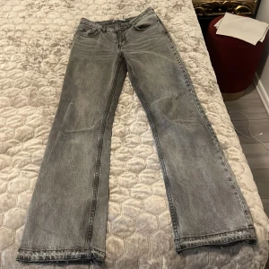 Gråa bootcut jeans  - Säljer ett par grå bootcut jeans och klassisk femficksdesign. Jeansen har low-mid midja och är i ett mjukt denimtyg. Perfekta för en avslappnad stil och passar till det mesta. Passar xs