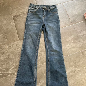 Blå bootcut jeans med normal passform - Säljer ett par klassiska blå bootcut jeans i storlek S. Köpta på by Chelsea💕