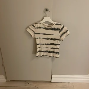 Vit och svart ribbad t-shirt från KappAhl  - Säljer en ribbad t-shirt från KappAhl i vitt och svart. Perfekt för dig som gillar en trendig och avslappnad stil.