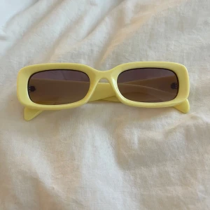 Gula rektangulära solglasögon - Snygga solglasögon med rektangulära bågar i ljusgul plast och mörka linser. Perfekt accessoar för att sticka ut och ge en färgklick till din outfit.