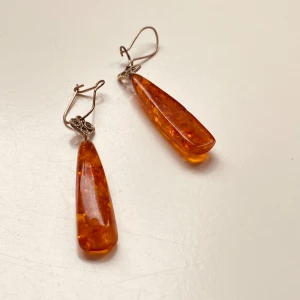 Örhängen med bärnsten - Snygga örhängen med droppformade hängen i bärnsten och silverfärgade krokar. Perfekta för att ge en färgklick till din outfit.