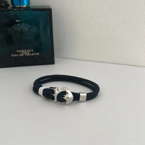 Blått armband med silverfärgat ankare - Stilrent armband i marinblått rep med ett silverfärgat ankare som lås. passar både till vardags och till mer uppklädda tillfällen. Enkel att justera storlek och Enkelt att trä på