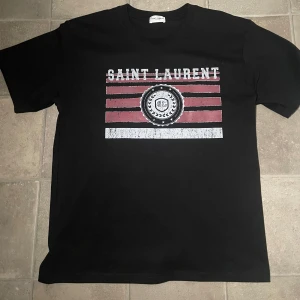 Saint Laurent T-shirt - Tja, säljer en svart Saint Laurent T-shirt i storlek S. Tröjan är i bra skick och har du frågor eller vill ha mer bilder är det bara att höra av sig