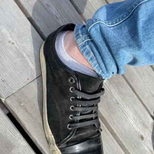 Svarta sneakers från Lanvin - Svarta sneakers från Lanvin med klassisk design, svarta skosnören och rund tå. Skorna har en svart sula och är tillverkade i skinn. Perfekta för en stilren och avslappnad look. Skick 5,5/10. 