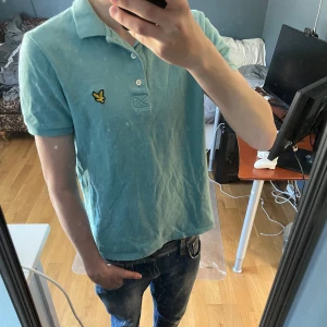 Ljusblå piké från Lyle & Scott - Säljer en ljusblå piké från Lyle & Scott. Tröjan har korta ärmar och den ikoniska gula loggan broderad på bröstet. Storlek S, men har krympt lite så typ XS. Inga defekter förutom att den är lite skrynklig