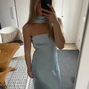 Ljusblå långklänning med draperad rygg - Säljer en superfin ljusblå långklänning från Hello Molly som går att bära på två sätt, som ni kan se på bilderna. Klänningen har en figurnära passform och är tillverkad i ett glansigt, mjukt material som ger en lyxig känsla. Det är några små små revor i tyget fram men som verkligen inte syns på håll. Priset går att diskutera och det är bara att fråga om ni vill ha fler bilder eller har några frågor!!