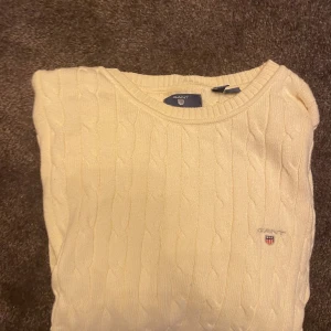 Kabelstickad tröja från Gant - Kabelstickad beige tröja från Gant med rund halsringning och diskret broderad logga på bröstet. Modellen är 170cm. Är uppe för förhandling. Ifall du har någon beundran hesitera inte att fråga.
