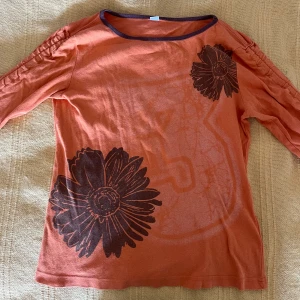 Vintage topp  - Väldigt fin vintage topp med blommor och rynkade ärmar. Man kan ha ärmarna båda ”långa” och korta beroende på hur mycket man drar i snörerna nedtill. Står ej någon storlek men skulle säga runt S. Skriv vid frågor eller liknande🥰