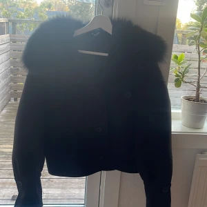 Svart pälsjacka från Meotine - Intressekoll på min super fina Meotine kappa!💕 Den är i storlek xs/s men tyvärr har två knappar vid fluffet ramlat av men jag har satt fast de med två säkerhetsnålar där knapparna ramlat av och det märks inte då!💖