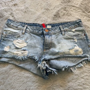 Lågmidjade jeans shorts - Jättefina lågmidjade jeans shorts med slitningar. Midjemått: 41 cm💞💞