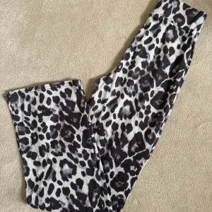 Leopardmönstrade byxor - Snygga mjuka byxor med leopardmönster i svart, grått och vitt. Perfekta för att sticka ut och ge outfiten lite edge. Mjukt och stretchigt material som sitter skönt hela dagen. Hög midja! 