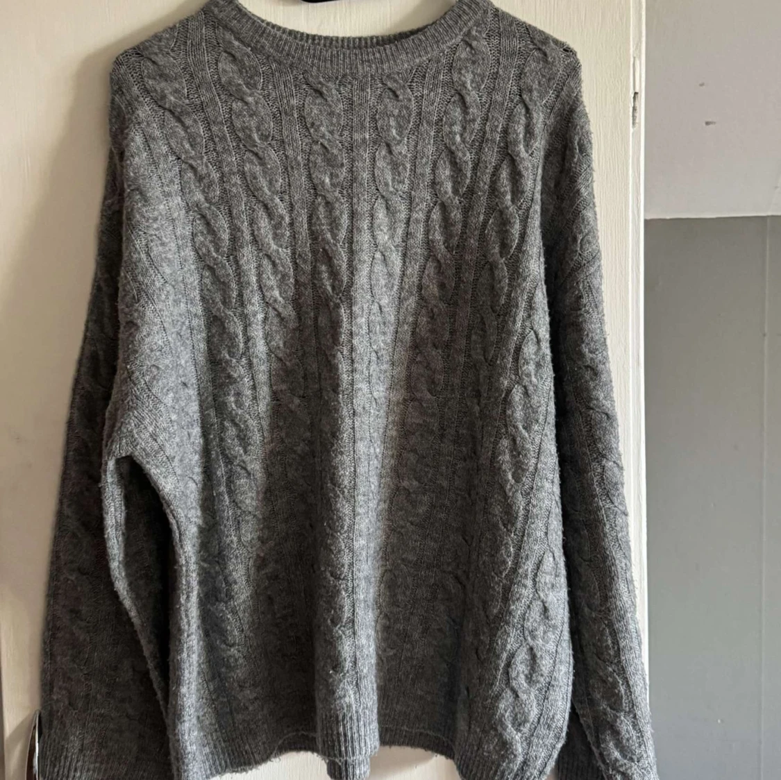 Grå kabelstickad tröja
