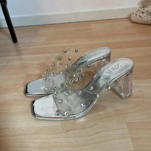 Klackar  - Klackar från Zara i storlek 37, aldrig använda. Tyvärr har plasten där ”diamanterna” suttit gulnat lite, som man kan se på bilderna. Men ingenting som syns väl på fötterna. 9cm.