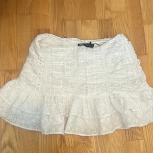 Vit volangkjol från Zara - Supersöt vit kjol från Zara med broderade detaljer och volanger. 