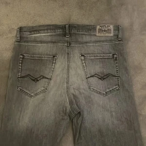 Grå Replay jeans - Säljer ett par grå jeans från Replay med klassisk femficksdesign och Replay-logga vid fickan fram. storlek 16 år/166 motsvarar typ 28/32  i modell Thad(pris går att diskutera)