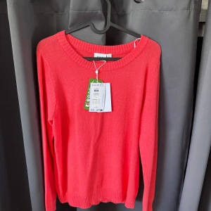 Korallrosa stickad tröja från Vila - Säljer en fräsch korallrosa stickad tröja från Vila. Tröjan har rund halsringning och långa ärmar. Yröjan är jättemjuk och aldrig använd, prislappen är kvar! Nypris: 329kr