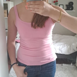 Ljusrosa linne - En ljusrosa, tight linnetopp med smala axelband. Perfekt för varma dagar eller som lager under andra plagg. Enkel och stilren design som passar till mycket. Väldigt skön och stretchig. Säljer för att jag personligen inte tycker färgen passar mig.🩷 Passar nog XS till M. Fått av min mamma, och inga lappar kvar. Därav vet jag inte vilket märke. TROR linnet är 100% bomull.