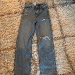 Blå high waist jeans!! - Säljer ett par blå jeans från H&M med slitningar och vida ben. Jeansen har hög midja. Perfekta för en avslappnad och trendig look. Aldrig använda då för långa 🙏🏼 skriv om frågor ❤️
