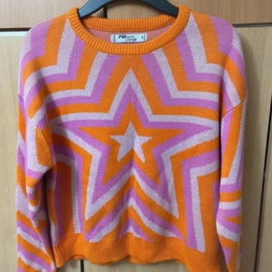 Stickad tröja - Färgglad stickad tröja från FB Sister med stora stjärnmönster i orange, lila och ljuslila.