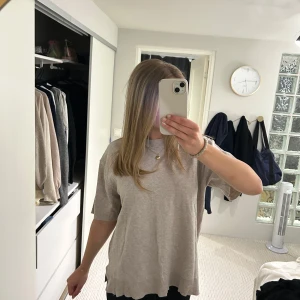 Beige t-shirt i bomull - Enkel och stilren beige t-shirt med rund hals och korta ärmar. T-shirten har en avslappnad passform och är tillverkad i mjukt bomullsmaterial. Perfekt för en chill vardagslook.
