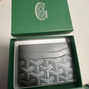 Grå korthållare  - Snygg och stilren korthållare  i grått med klassiskt mönster och flera kortfack. Perfekt accessoar för dig som vill ha något exklusivt och smidigt i fickan. Säg till om ni har frågor😊